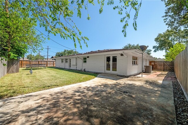 back of house with a patio area, a lawn, and french doors