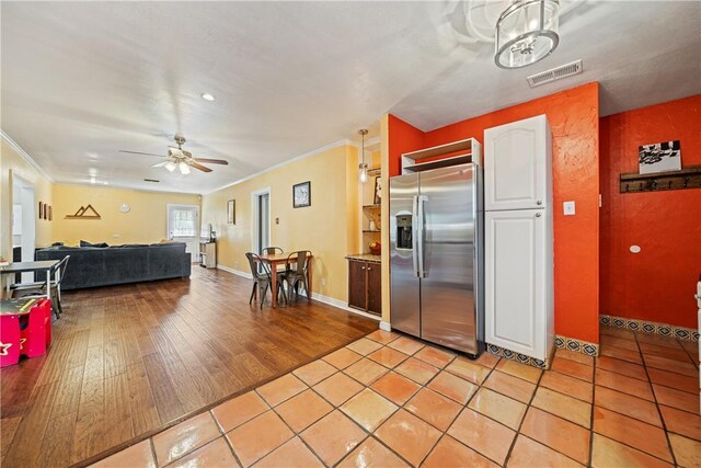 149 Rossiter St, Corpus Christi, TX 78411 - kitchen with stainless steel refrigerator with ice dispenser, ornamental molding, white cabinets, a ceiling fan, and light tile patterned floors