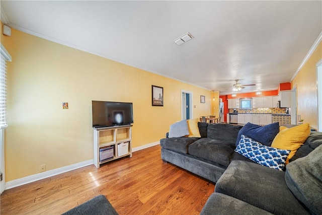 149 Rossiter St, Corpus Christi, TX 78411 - living room with crown molding, light wood finished floors, baseboards, and a ceiling fan