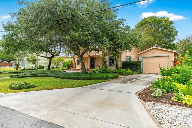 149 Rossiter St, Corpus Christi, TX 78411 - obstructed view of property featuring concrete driveway, a front yard, and a detached garage