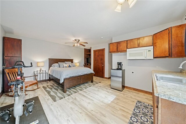 149 Rossiter St, Corpus Christi, TX 78411 - bedroom featuring a sink, light wood-style floors, baseboards, a ceiling fan, and freestanding refrigerator