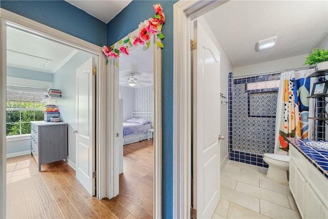149 Rossiter St, Corpus Christi, TX 78411 - bathroom featuring tiled shower, toilet, vanity, ensuite bathroom, and wood finished floors