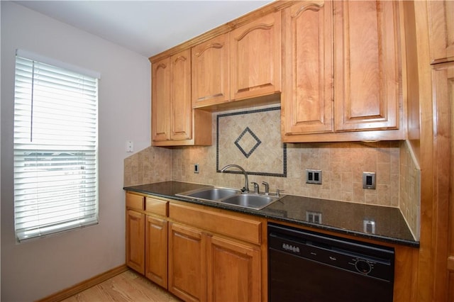 kitchen with baseboards, black dishwasher, decorative backsplash, dark stone countertops, and a sink