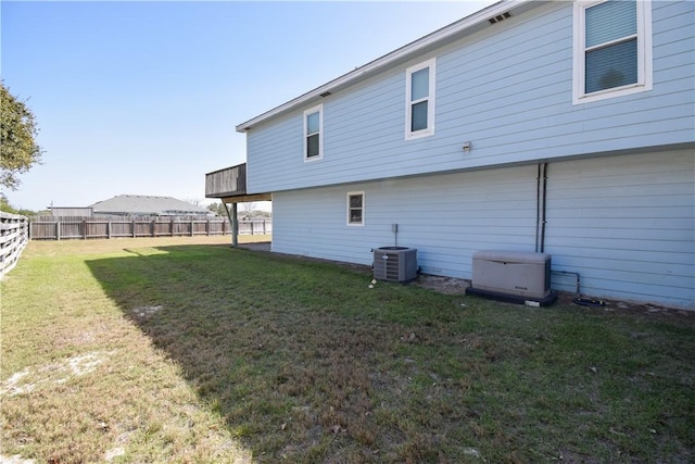 back of house featuring cooling unit, a yard, and fence