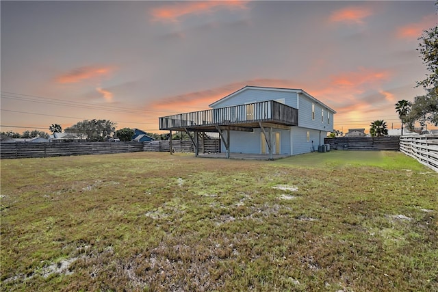 rear view of property featuring stairway, a deck, a yard, and a fenced backyard