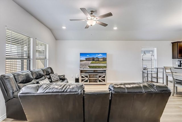 living room featuring hardwood / wood-style flooring, ceiling fan, and vaulted ceiling