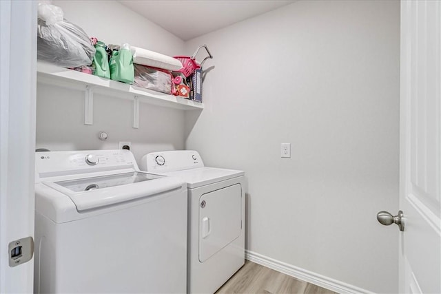 washroom with laundry area, baseboards, light wood-style floors, and washer and dryer