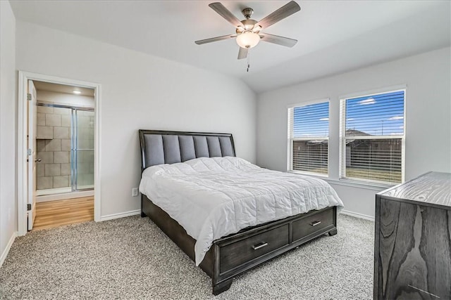 carpeted bedroom featuring ensuite bath, ceiling fan, and lofted ceiling