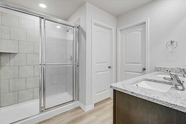 bathroom featuring vanity, hardwood / wood-style flooring, and an enclosed shower