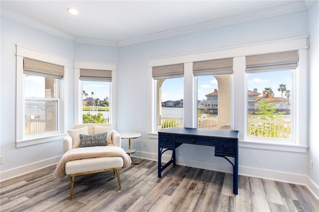 living area featuring a water view, hardwood / wood-style floors, and crown molding