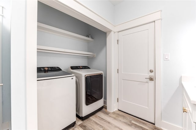 laundry room featuring washer and dryer and light hardwood / wood-style flooring