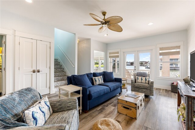 living room with light wood-type flooring, french doors, and ceiling fan