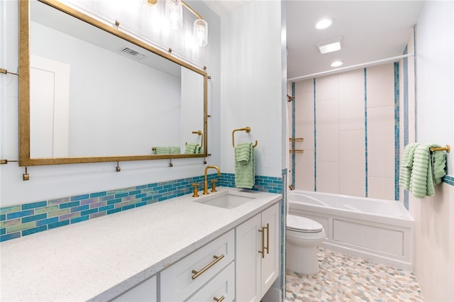 full bathroom with vanity, tile patterned floors, toilet, decorative backsplash, and tiled shower / bath combo