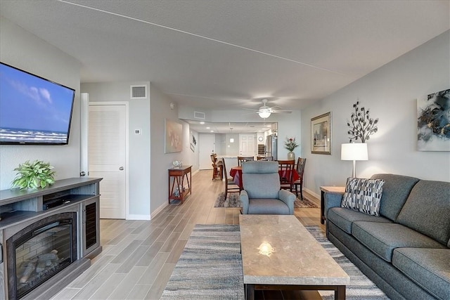 living room featuring ceiling fan and light hardwood / wood-style floors