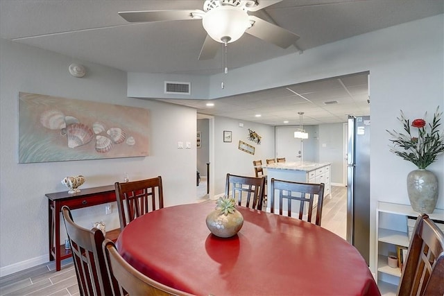 dining area featuring ceiling fan and light wood-type flooring