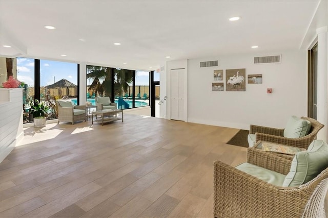 sitting room featuring expansive windows and light hardwood / wood-style flooring