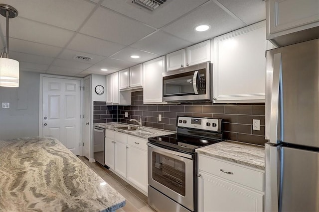 kitchen with white cabinetry, sink, a drop ceiling, and appliances with stainless steel finishes