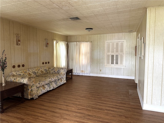 living room featuring dark wood-type flooring and wood walls