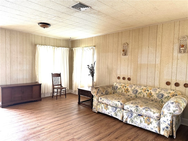 living room featuring hardwood / wood-style floors and wooden walls