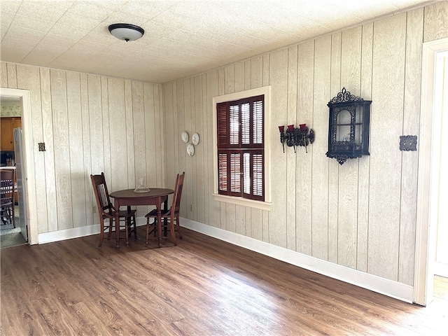 dining room with wood walls and wood-type flooring