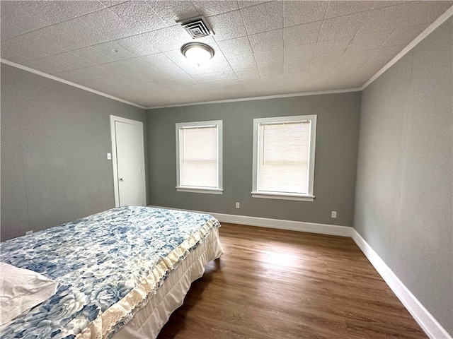 unfurnished bedroom featuring dark hardwood / wood-style floors and crown molding