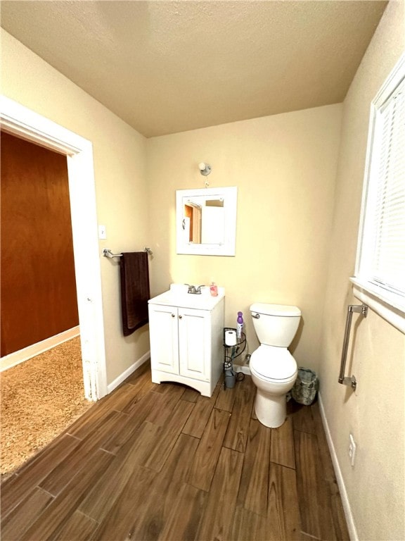 bathroom featuring hardwood / wood-style floors, vanity, a textured ceiling, and toilet