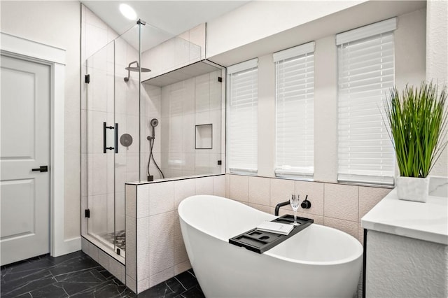 bathroom with a soaking tub, a shower stall, and marble finish floor