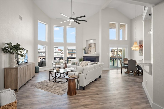 living room with visible vents, baseboards, a ceiling fan, light wood-type flooring, and a fireplace