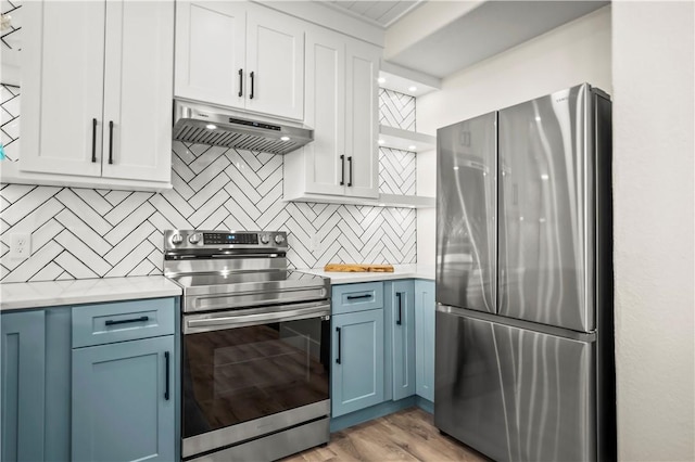 kitchen with blue cabinets, under cabinet range hood, stainless steel appliances, and light countertops