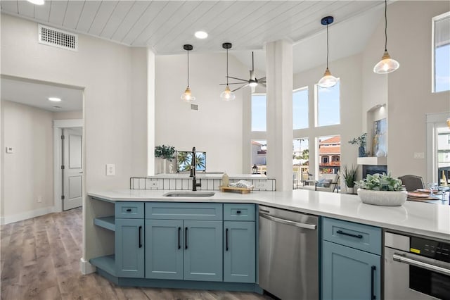 kitchen with visible vents, appliances with stainless steel finishes, wood finished floors, light countertops, and a sink