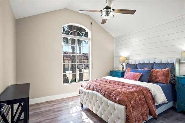 bedroom featuring vaulted ceiling, wood finished floors, a ceiling fan, and baseboards