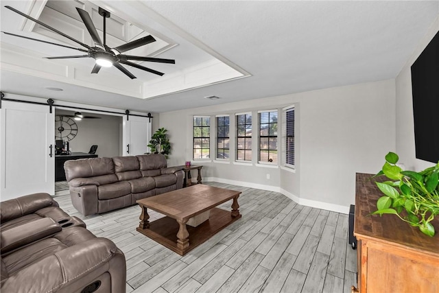 living room featuring light wood-type flooring, a barn door, and ceiling fan