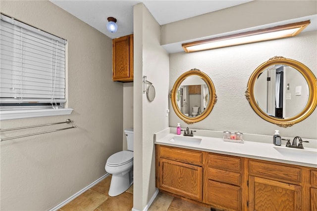 bathroom with tile patterned flooring, vanity, and toilet