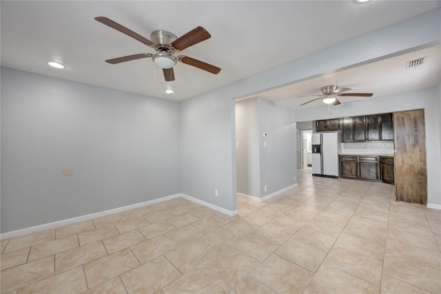 unfurnished room featuring light tile patterned floors, visible vents, baseboards, and ceiling fan