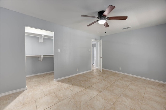 unfurnished bedroom featuring visible vents, baseboards, light tile patterned flooring, ceiling fan, and a closet