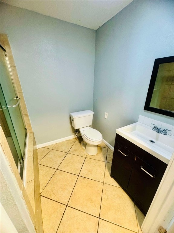 bathroom with toilet, vanity, an enclosed shower, and tile patterned flooring