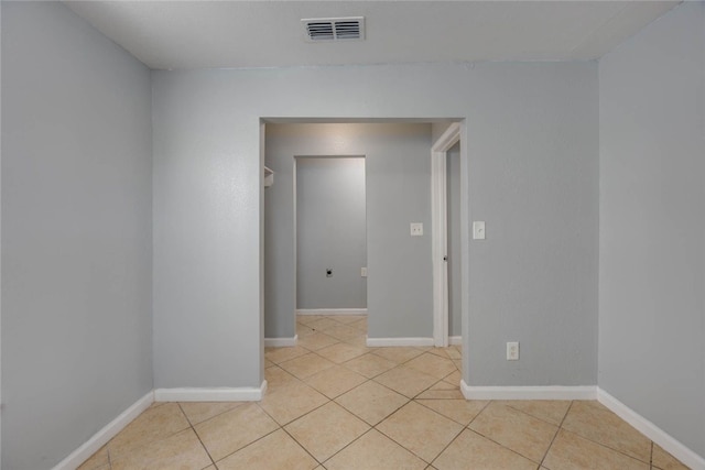 empty room featuring visible vents, baseboards, and light tile patterned flooring