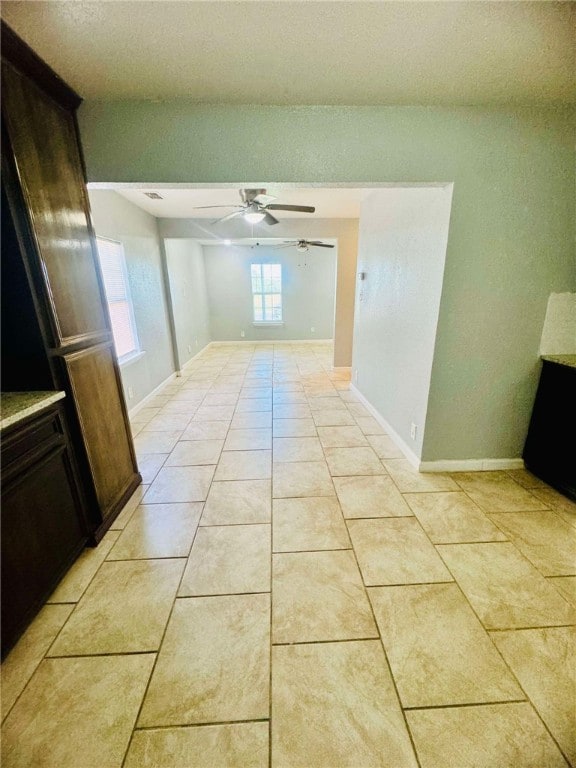 hallway with a wealth of natural light and light tile patterned flooring