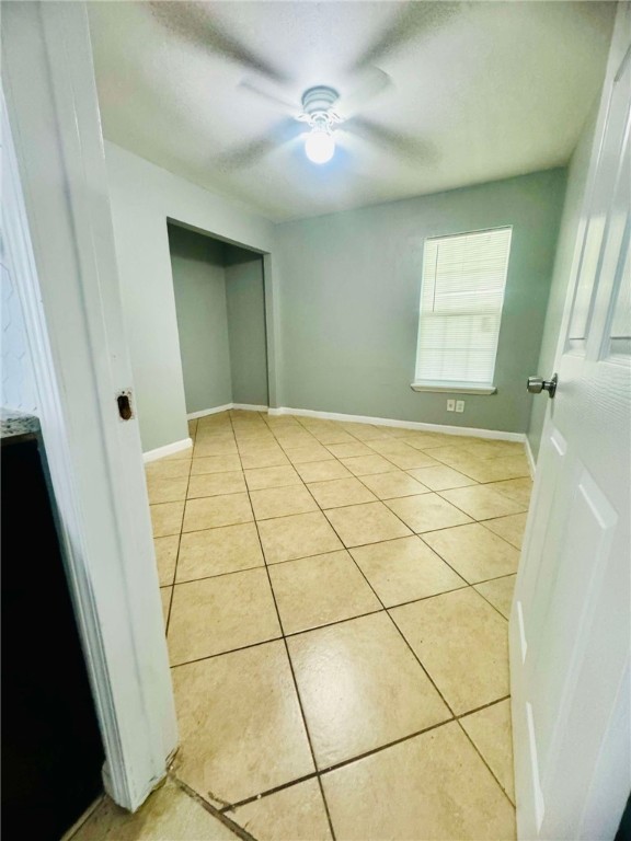 unfurnished bedroom featuring ceiling fan and light tile patterned flooring