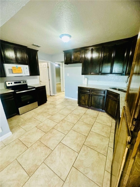 kitchen with tasteful backsplash, stainless steel range with electric cooktop, a textured ceiling, light tile patterned floors, and sink