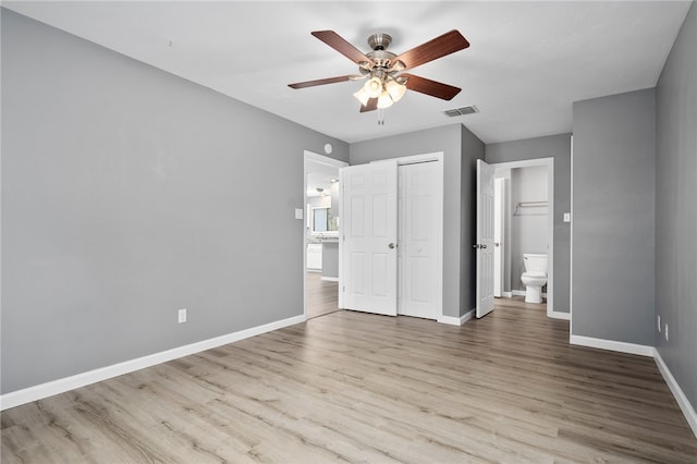 unfurnished bedroom featuring ceiling fan, ensuite bathroom, and light hardwood / wood-style floors