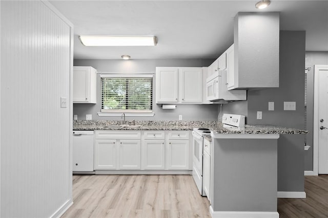 kitchen with sink, white cabinetry, light stone counters, white appliances, and light hardwood / wood-style floors