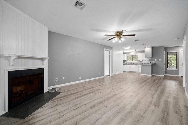 unfurnished living room featuring ceiling fan and light hardwood / wood-style floors