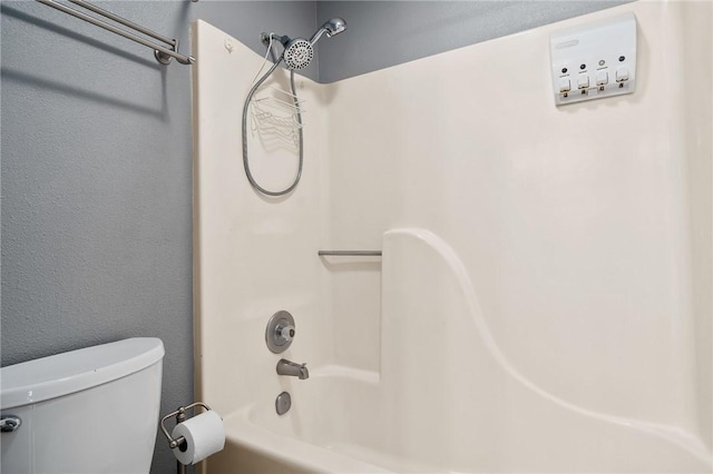 bathroom featuring bathing tub / shower combination and toilet