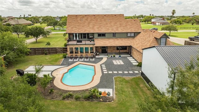 view of swimming pool featuring exterior bar, a lawn, and a patio