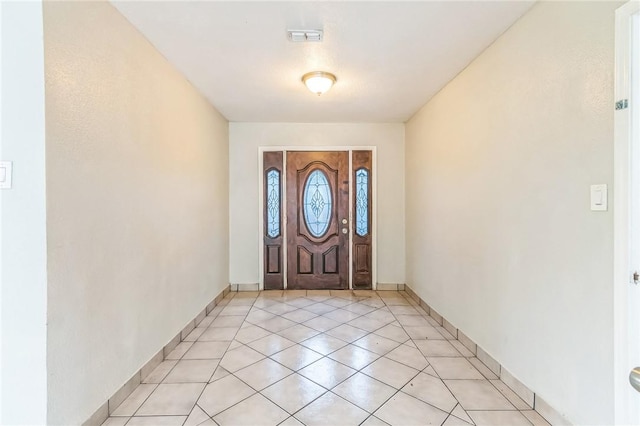 foyer with visible vents, baseboards, and light tile patterned floors