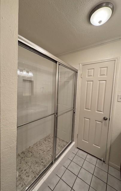 4202 Wolf Creek Dr, Corpus Christi, TX 78413 - bathroom with tile patterned floors, a shower stall, and a textured ceiling
