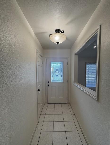 4202 Wolf Creek Dr, Corpus Christi, TX 78413 - doorway with light tile patterned floors and a textured wall