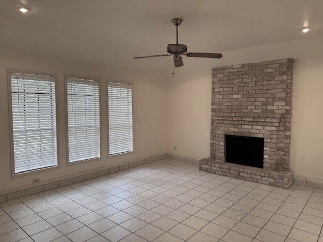 4202 Wolf Creek Dr, Corpus Christi, TX 78413 - unfurnished living room featuring ceiling fan, light tile patterned floors, a brick fireplace, and recessed lighting