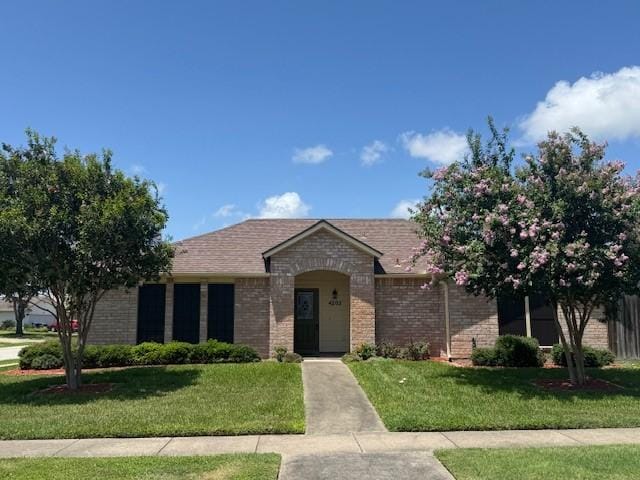 4202 Wolf Creek Dr, Corpus Christi, TX 78413 - view of front facade featuring a front yard and brick siding
